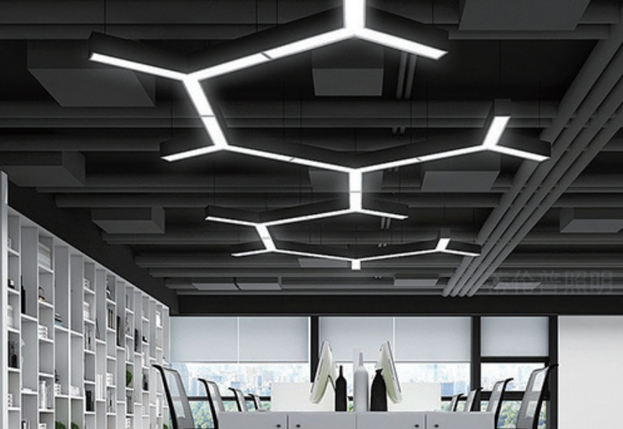 LED Shape Pendant Light Office Application - hexagonal geometric pendant light installation on dark ceiling open plan office workspace white desks black chairs modern commercial lighting